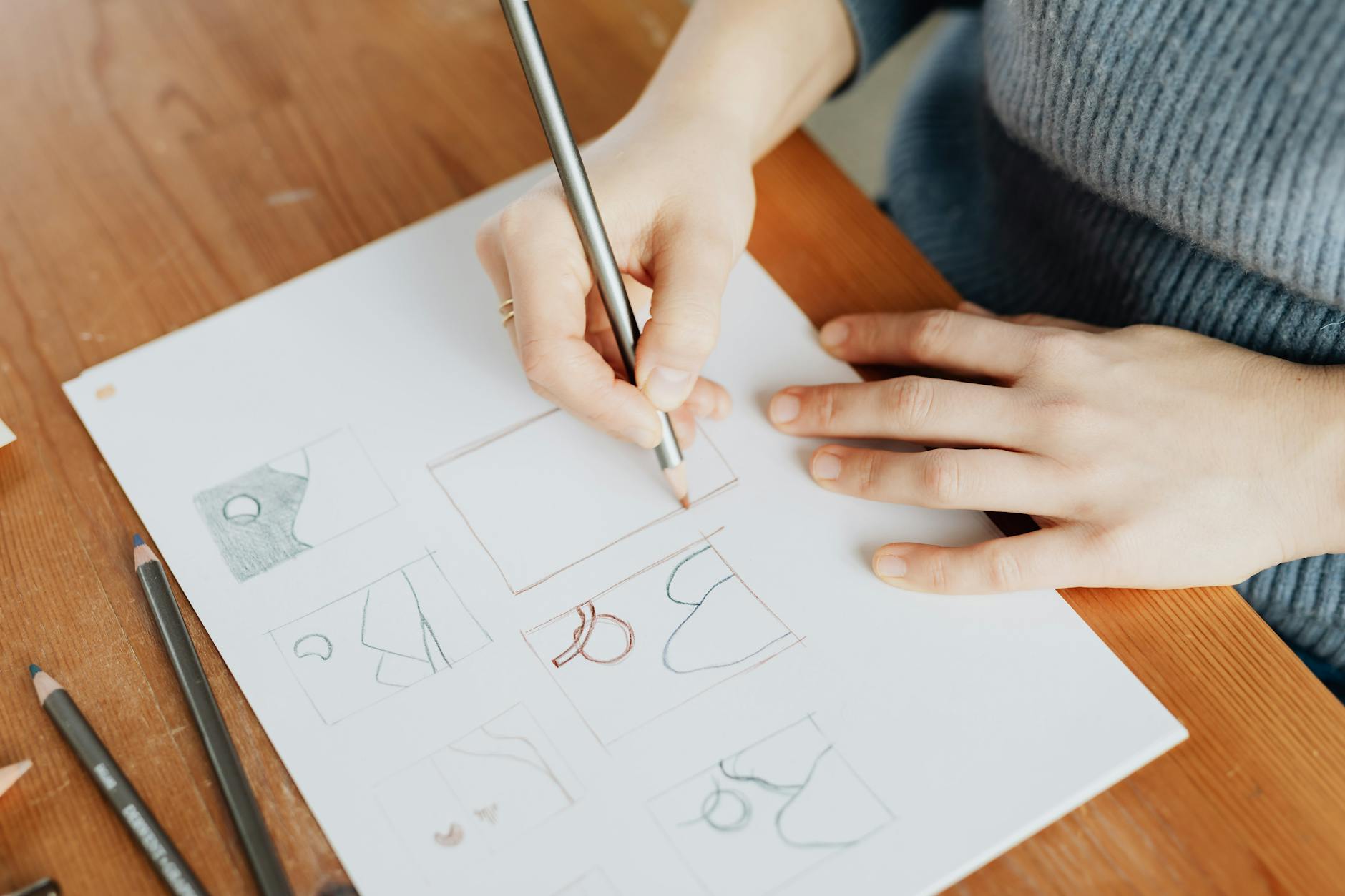 crop unrecognizable female architect making sketch with pencil at work