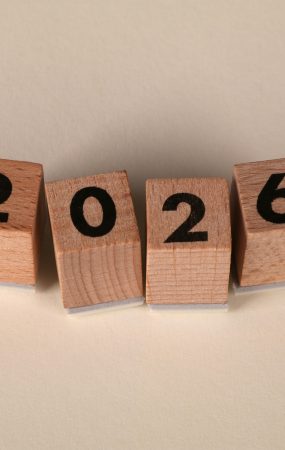 Wooden cubes forming the year 2026 on a neutral background.