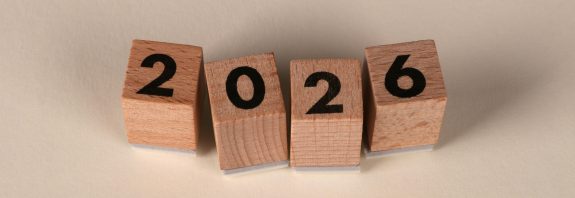 Wooden cubes forming the year 2026 on a neutral background.